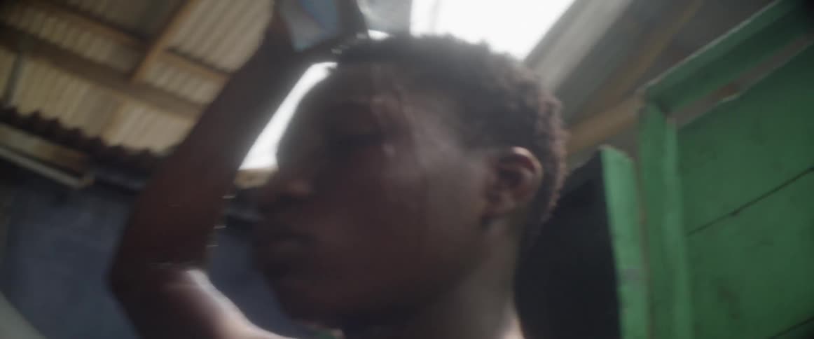 A man pours water on himself as he shakes his head