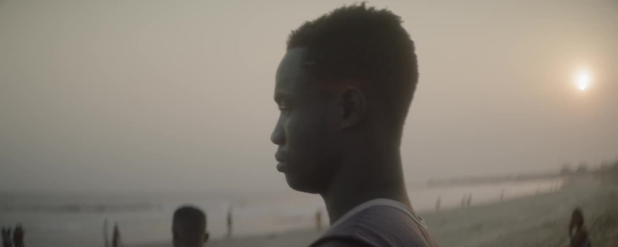 A man standing on a beach and looking out into the sea