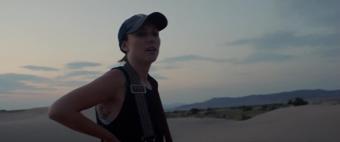 A woman stands and catches her breath in the desert