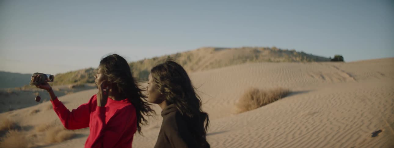 Woman records herself and another woman in the desert