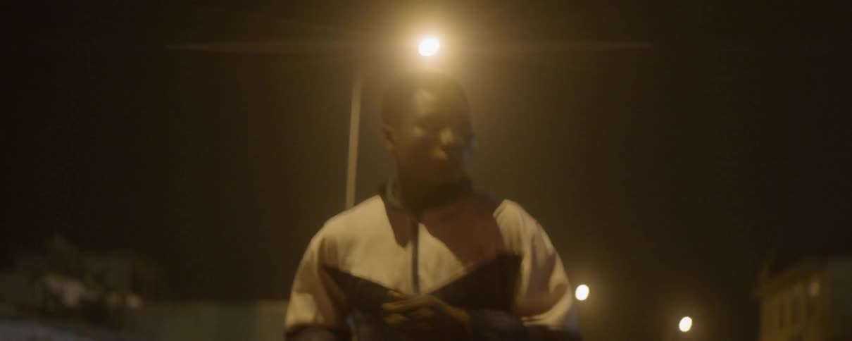 A young man jogs down a city street at night