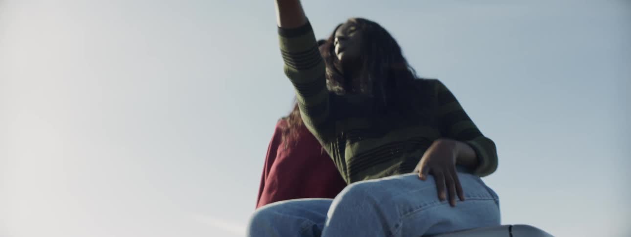 Woman jumps to top of car to sit with her friend and record a video