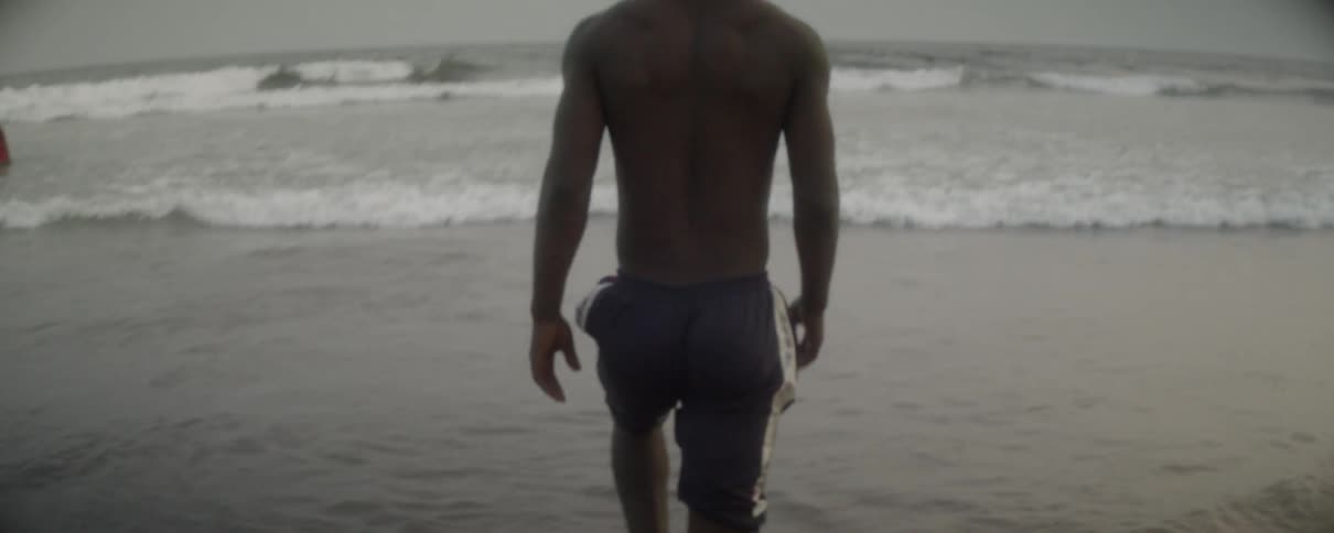 Man walks into water as waves come in