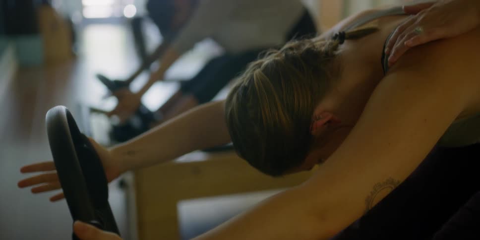 A group of females bending forward during an exercise routine