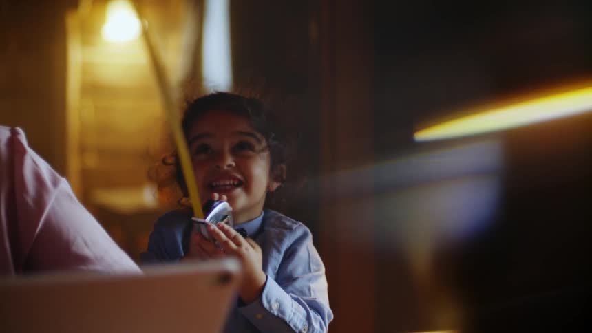 A little girl happily plays with a tape measure