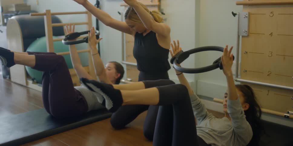 A woman coaching two women in a gym