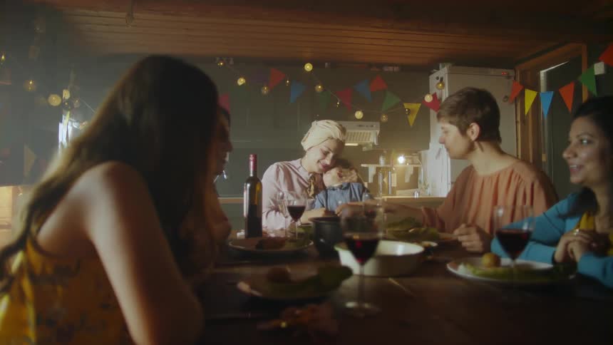 A group of women and a baby sit at a table in a room decorated for a party
