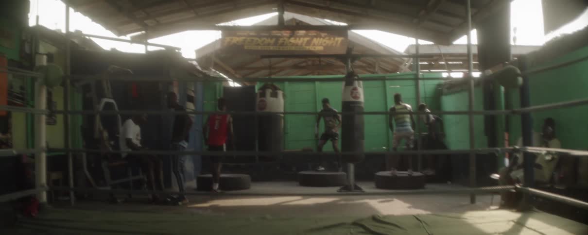 Several men jump up and down on small platforms in an open air gym
