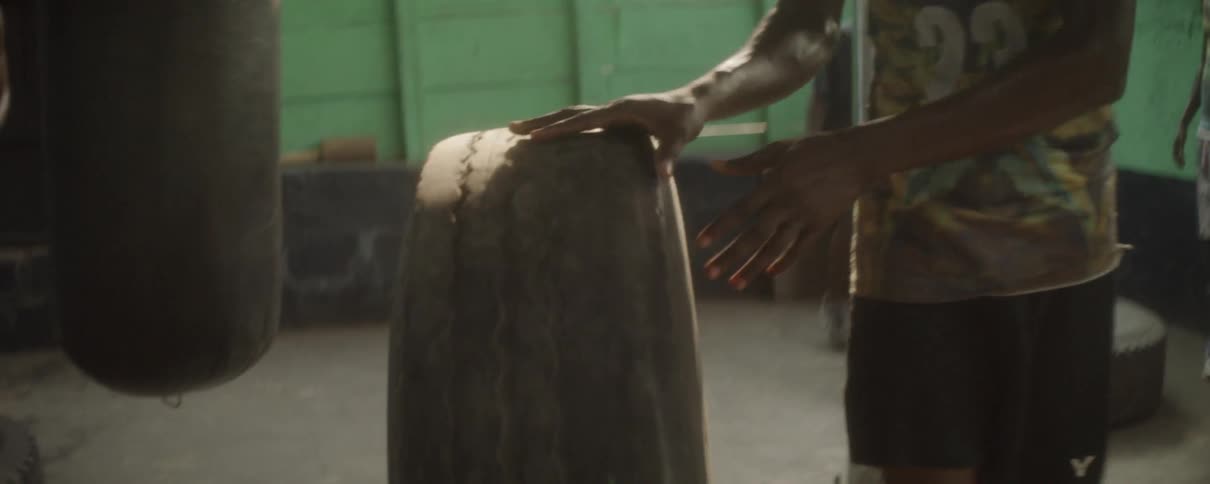 A man rolling a tire around in a shop