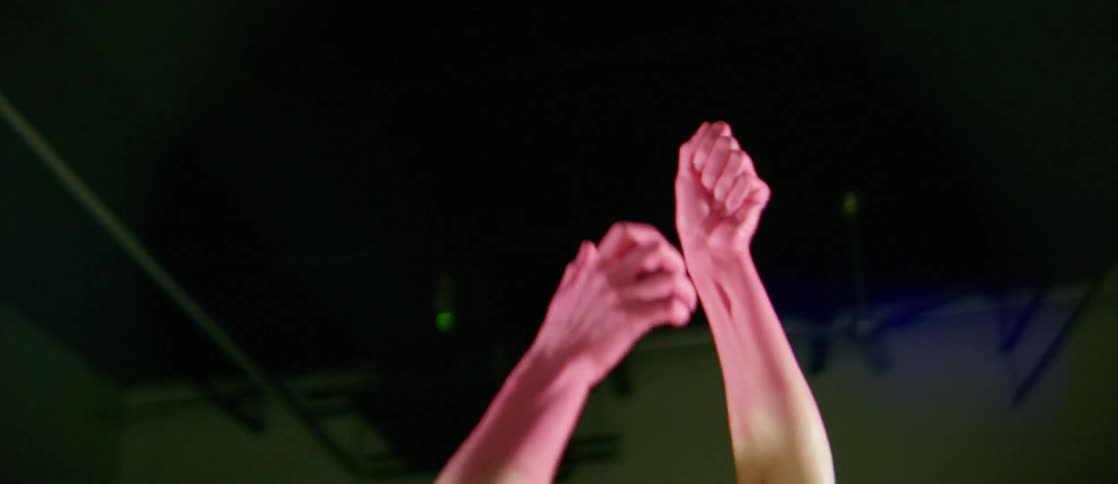 A woman is reaching towards the ceiling