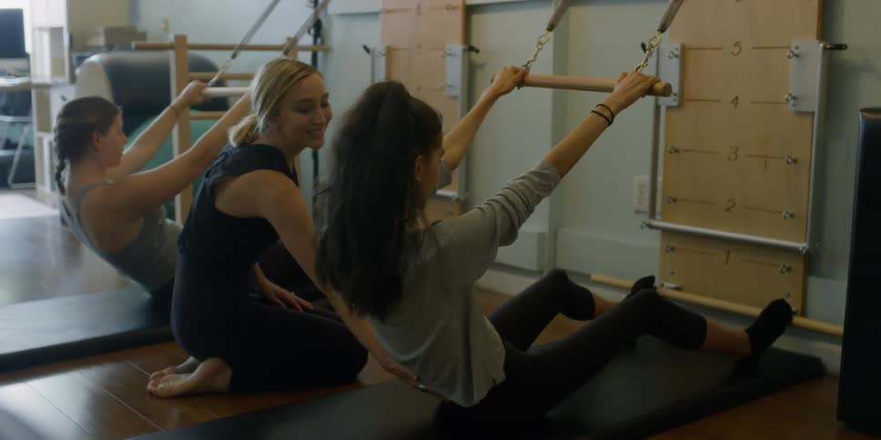 Woman instructs two women exercising in a gym