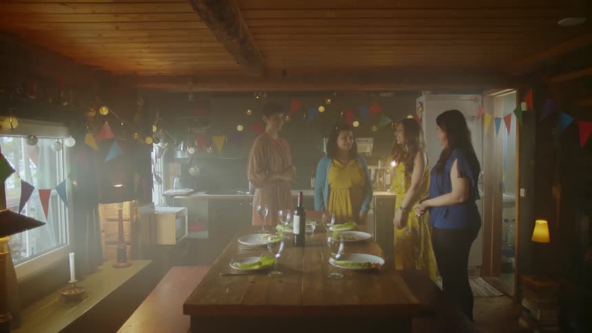 Some people are standing in a room with the table set