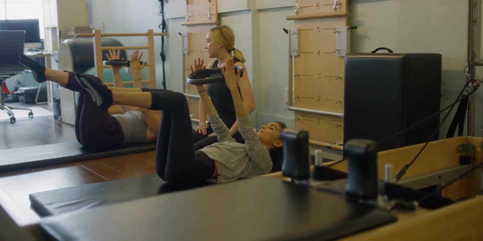 Fitness instructor helps two women exercise