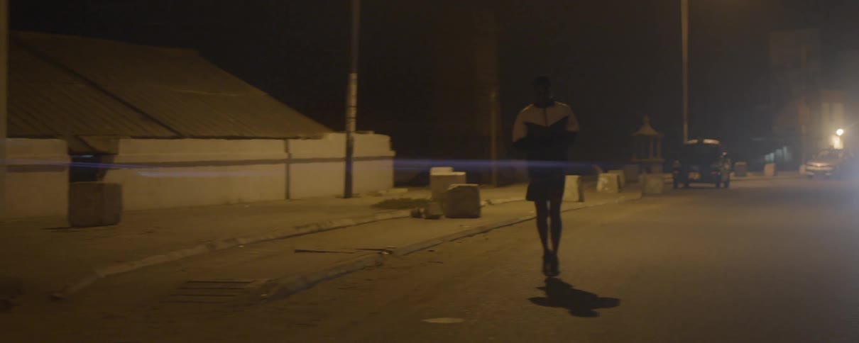 A man runs down the street at night