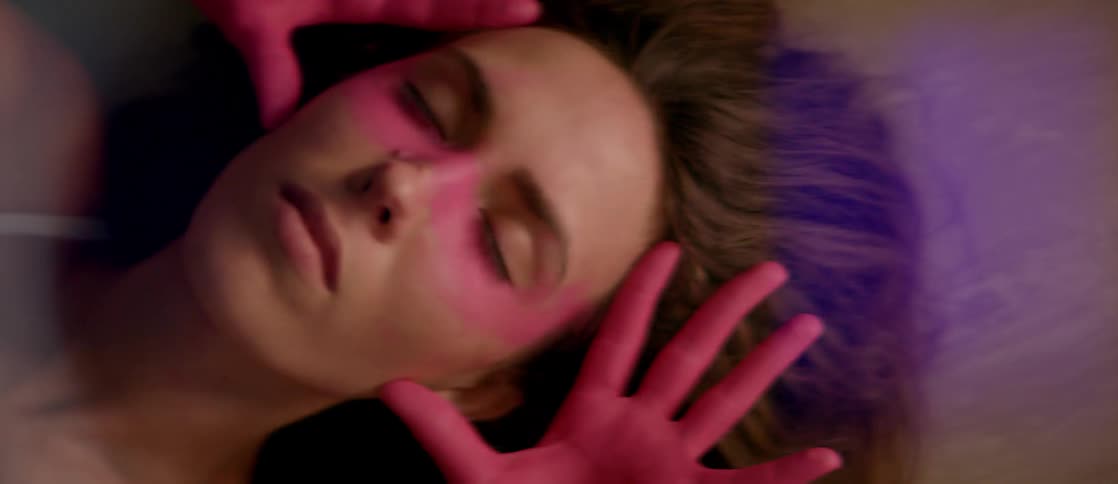 A woman covers her face with the back of her hands in an abstract dance routine