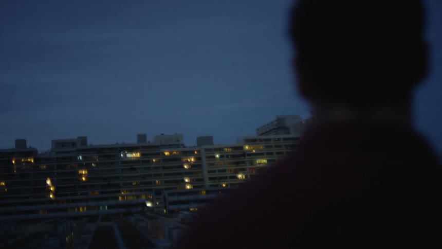 silhouette of a man in front of the olympic village by night