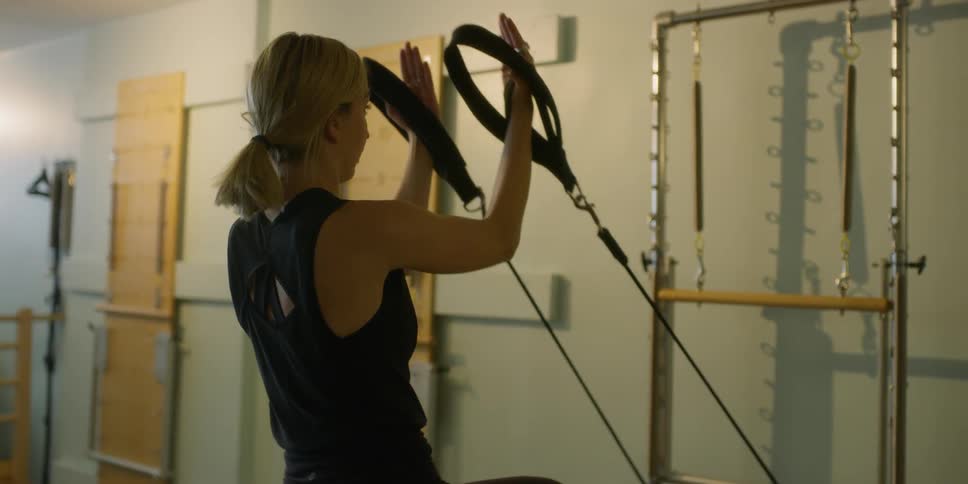 A woman pulls on an elastic work out device