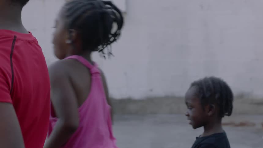 Three children walk outside in the city