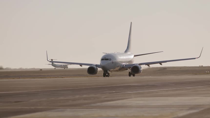 Two planes moving down the runway