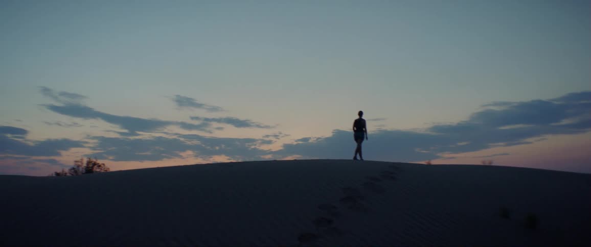 Woman Exploring Sand Dunes At Dusk