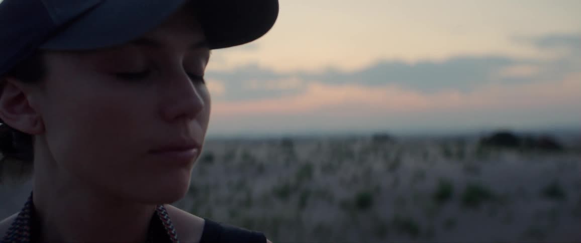 Woman standing in a field with her eyes closed