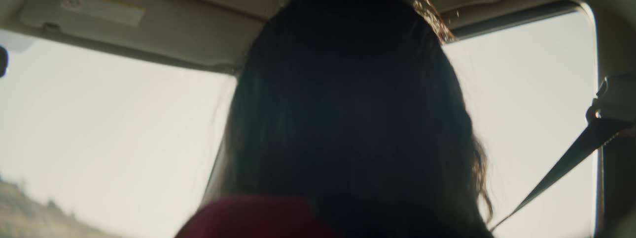 A woman looking at her surroundings as a passenger in a vehicle