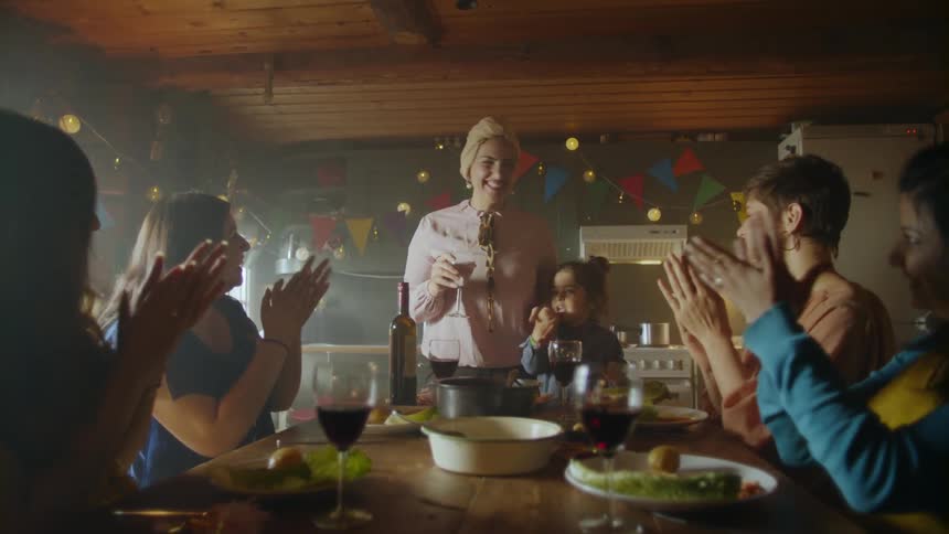 A woman stands up and makes a toast at a table with other women