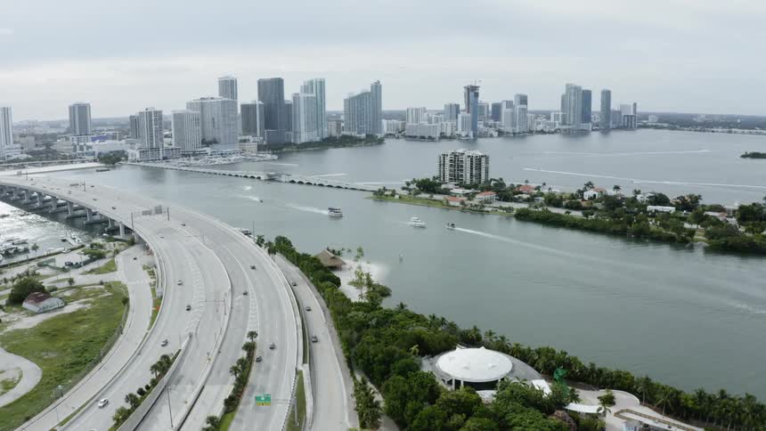 A landscape showing a highway, body of water, and a city in the background