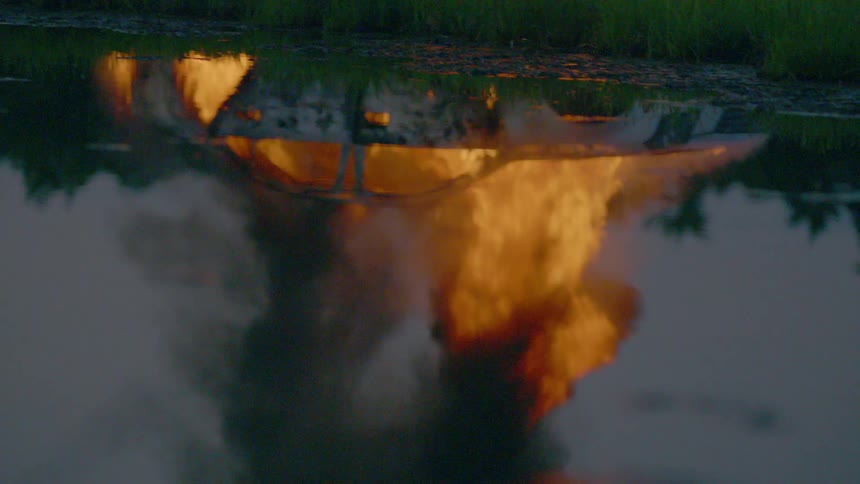 A car burns upside down in the darkness