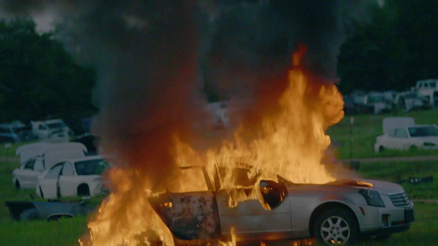 A car burns in a junkyard