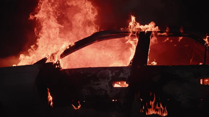Frame of a car burns brightly on fire at night