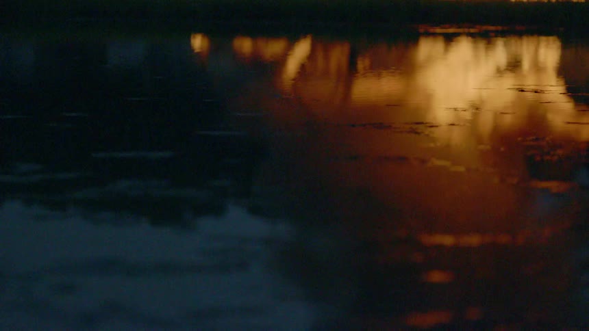 Body of water with fire in the distance