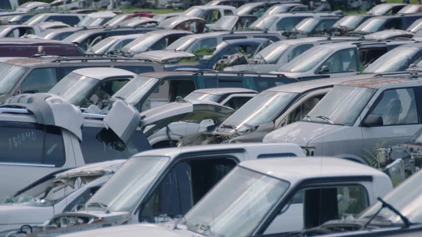 Highly damaged vehicles all tightly parked beside each other