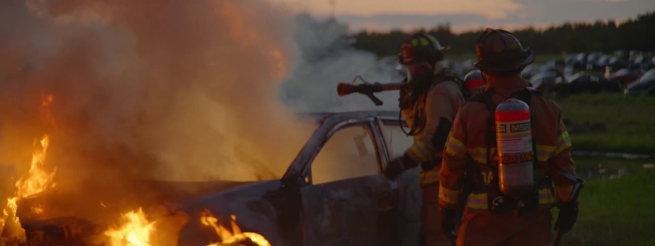 Firemen attempt to extinguish a car that had been lit on fire