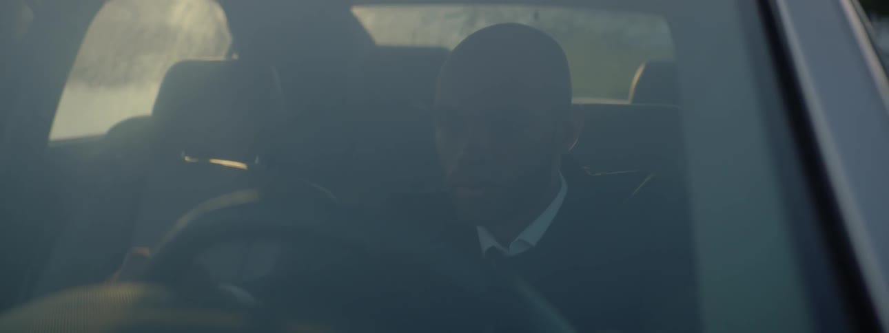 Man in a suit sitting in the front seat of a car