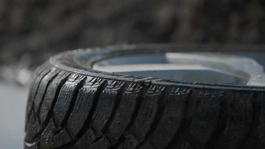 Sun shines on a tire in the middle of a road