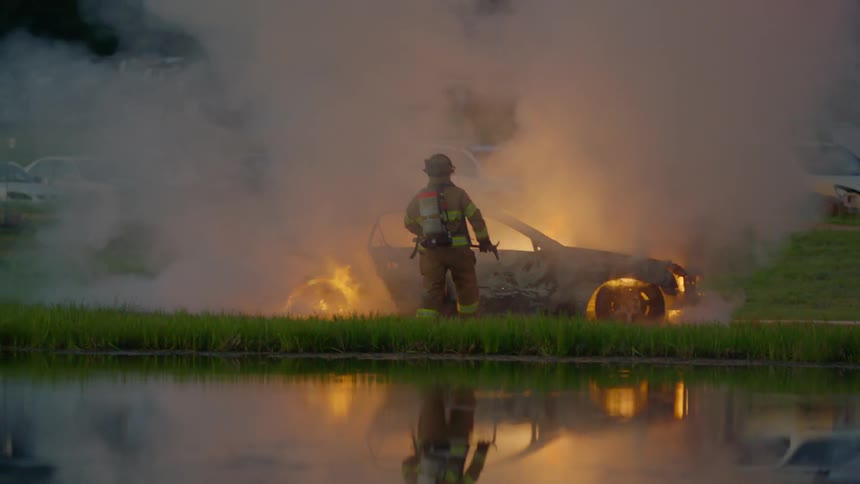 Firefighters putting out a fire in a car