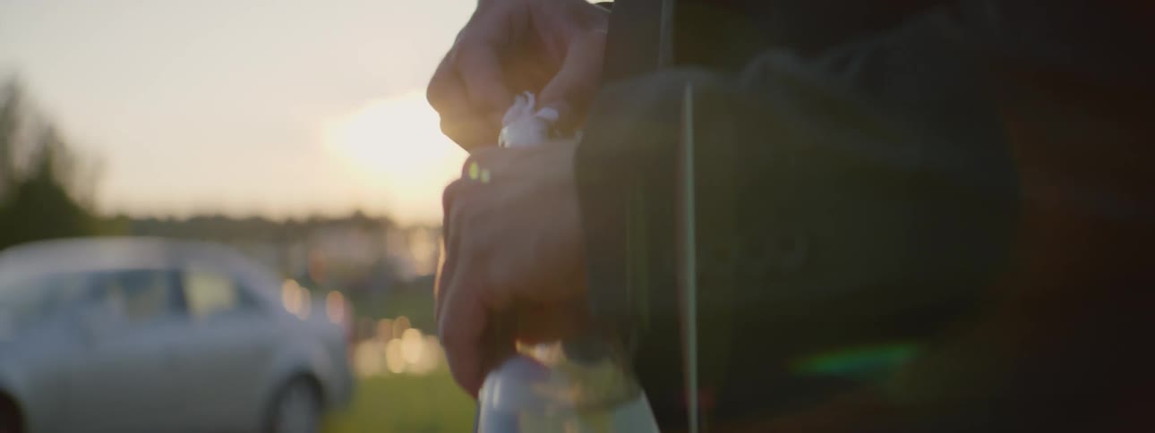 A person attempting to put a piece of cloth in a bottle