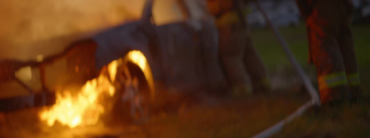 Firemen Extinguishing Burning Car