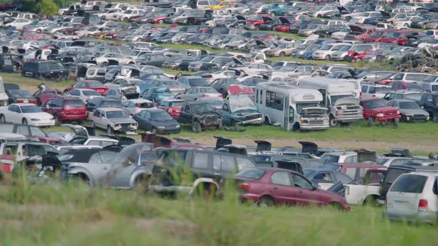 Panning across a field of a junkyard