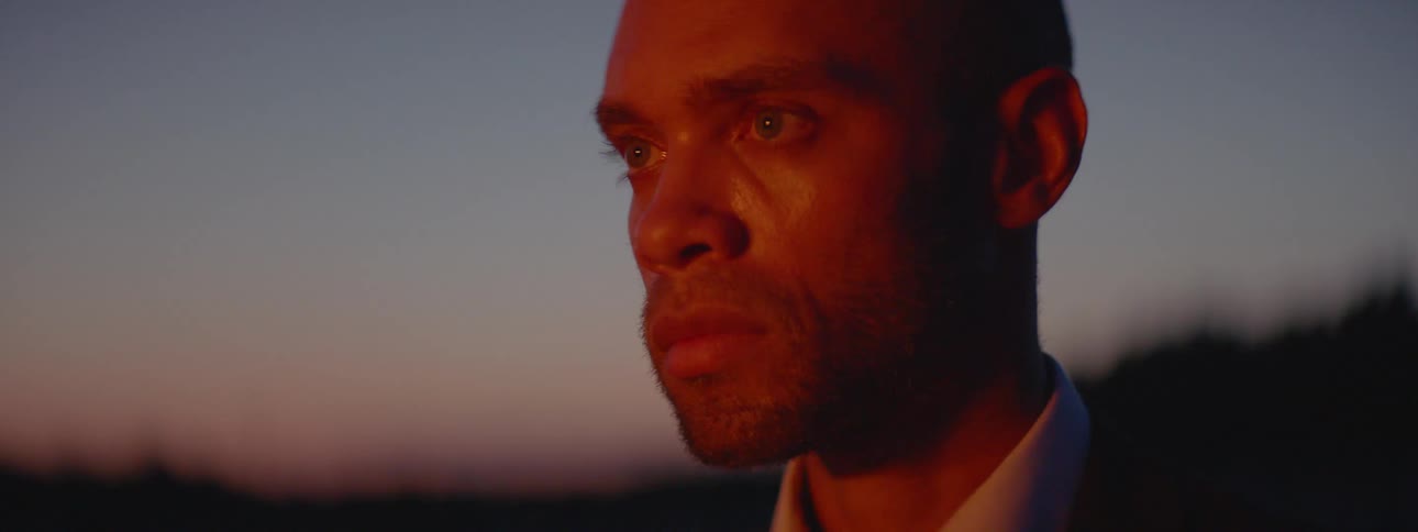 A man stares intensely at a fire