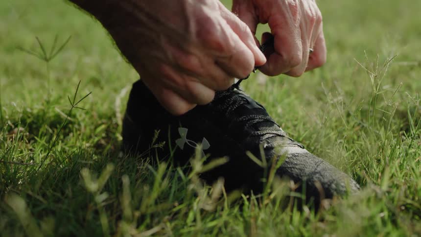 A man is tying his shoe