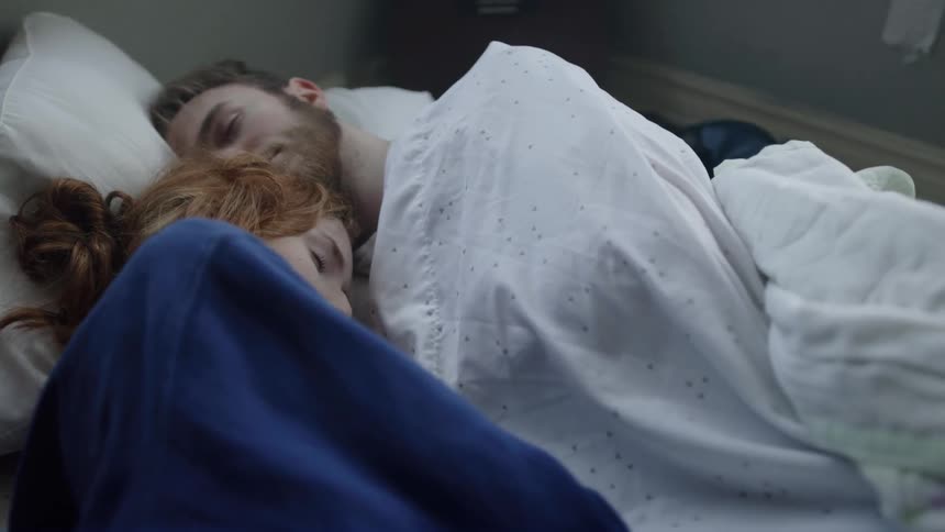 Man and woman sleeping together in a bed