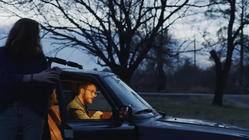 A man and woman are getting out of a car
