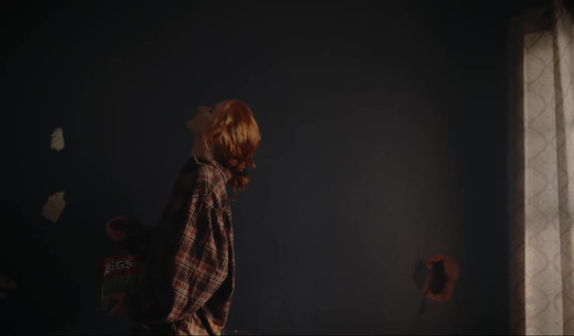 A woman walking through a house and eating candy