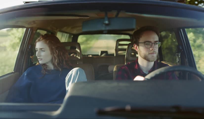 Man and woman driving in car down country road