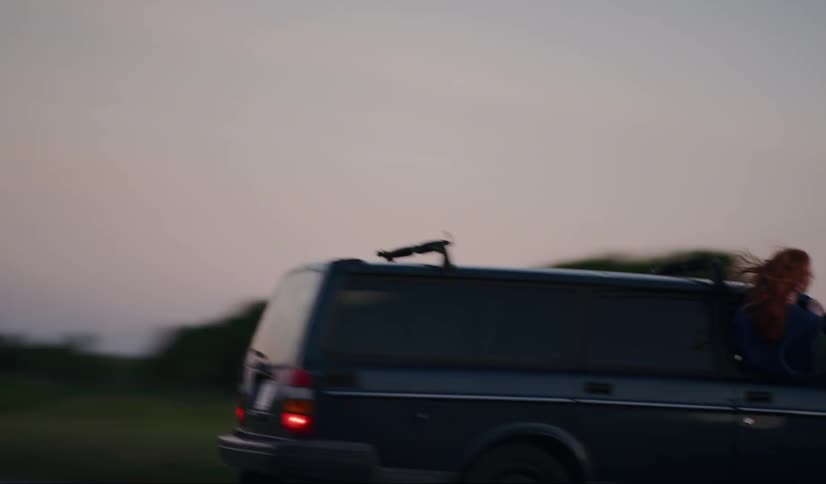 A female is hanging out of the window in a vehicle