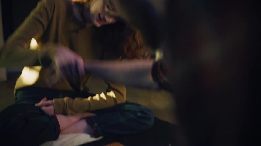 A man and woman are play fighting over a game of checkers
