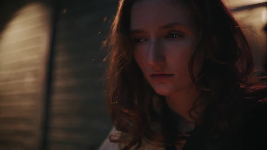 Woman in a dark alley staring at something