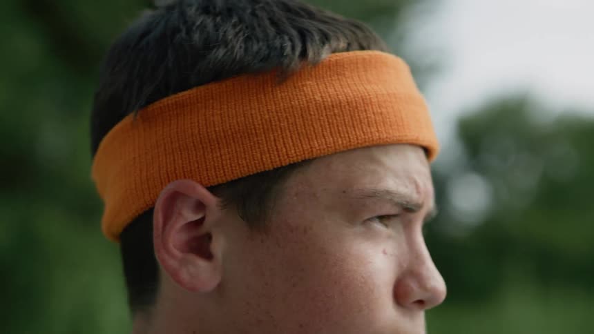 A young teen puts a headband on his head